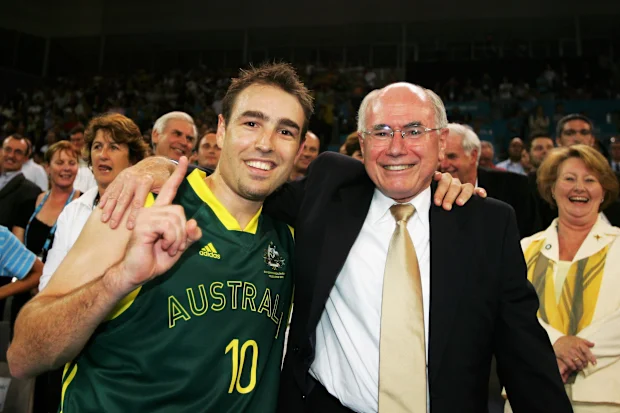 MELBOURNE, AUSTRÁLIA - 24 DE MARÇO: (LR) Jason Smith da Austrália comemora com o primeiro-ministro australiano John Howard após a vitória da seleção australiana no jogo de basquete masculino pela medalha de ouro entre Austrália e Nova Zelândia no Melbourne Park Multi Purpose Venue durante o nono dia dos Jogos da Commonwealth de Melbourne 2006, 24 de março de 2006 em Melbourne, Austrália. (Foto de Cameron Spencer/Getty Images)