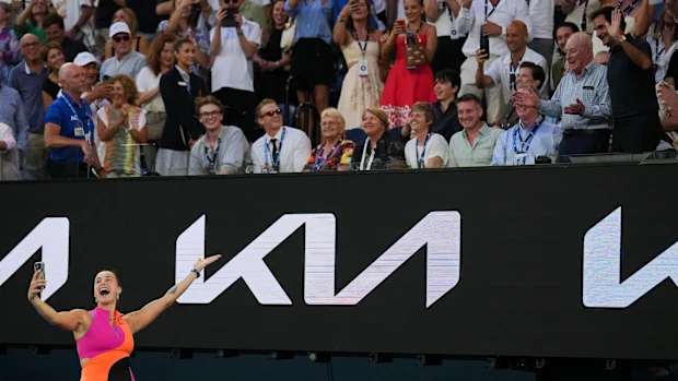 Aryna Sabalenka da Bielo-Rússia tira uma selfie com Rod Laver, segundo à direita, e Roger Federer, à direita, após derrotar Tiantsoa Rakotomanga Rajaonah da França em sua partida de primeira rodada do campeonato de tênis do Aberto da Austrália em Melbourne, Austrália, domingo, 18 de janeiro de 2026. (AP Photo/Dita Alangkara)