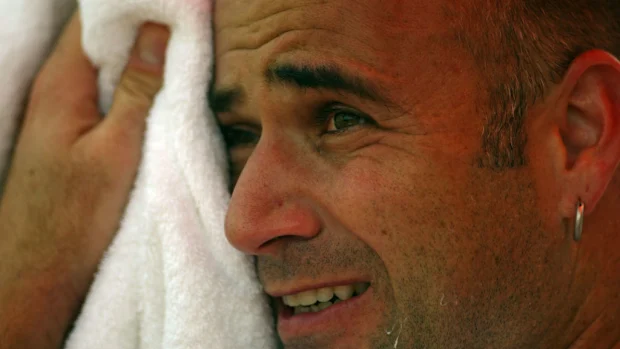 Andre Agassi sente o calor durante a partida contra Igor Andreev.