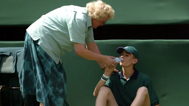 Um gandula recebe atenção após sentir o calor na quadra central de Wimbledon em 2005.