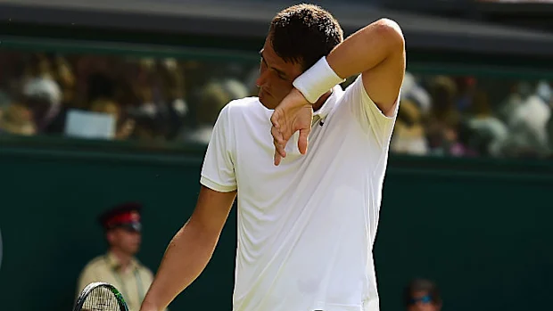 Bernard Tomic enxuga a testa na partida de 2015 contra Novak Djokovic.