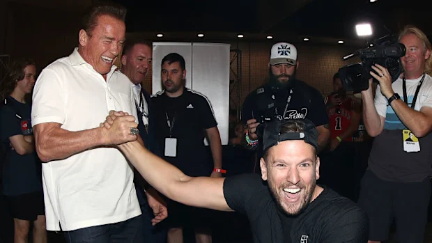 Arnold Schwarzenegger cumprimenta o campeão de tênis em cadeira de rodas do Aberto da Austrália, Dylan Alcott.