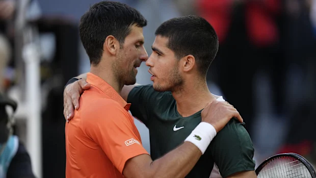 Novak Djokovic abraça Carlos Alcaraz no Aberto de Madrid.