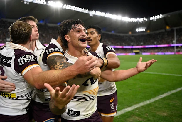 Kotoni Staggs, do Broncos, comemora após marcar um try.