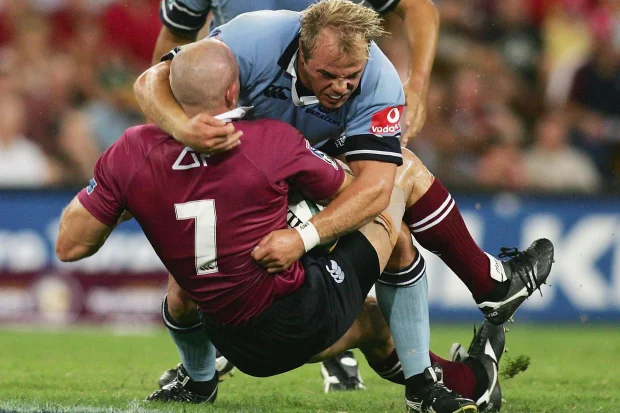 David Croft dos Reds é abordado por Phil Waugh dos Waratahs.