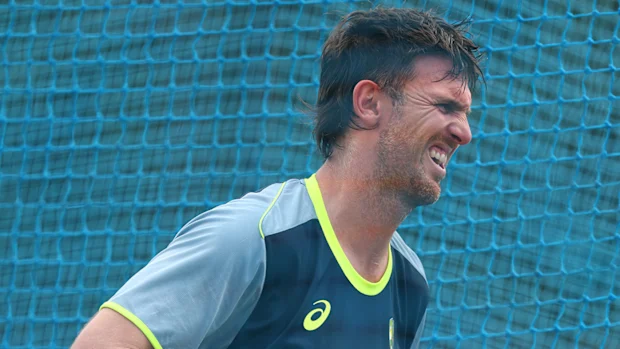 Mitchell Marsh reage após ser atingido pela bola durante um treino.
