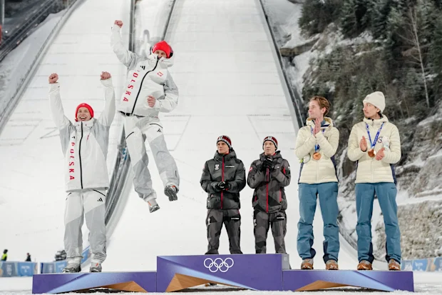 Os medalhistas de prata Pawel Wasek e Kacper Tomasiak, da Polônia, comemoram no pódio, com os medalhistas de ouro Stephan Embacher e Jan Hoerl, da Áustria, e os medalhistas de bronze Kristoffer Eriksen Sundal e Johann Andre Forfang, da Noruega, após a competição de superequipe masculina de salto de esqui nos Jogos Olímpicos de Inverno de 2026, em Predazzo, Itália, segunda-feira, 16 de fevereiro de 2026. (AP Photo / Evgeniy Maloletka)