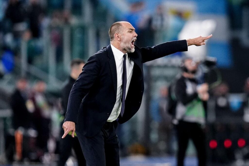 O técnico de futebol Igor Tudor vestindo terno e gravata na linha lateral durante um jogo e levantando o braço esquerdo para apontar