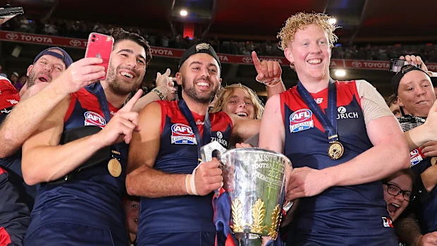 Christian Petracca, Christian Salem e Clayton Oliver dos Demons posam com a taça da premiership.