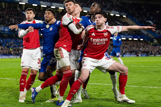 Jogadores do Arsenal e do Chelsea competem pela bola em escanteio.