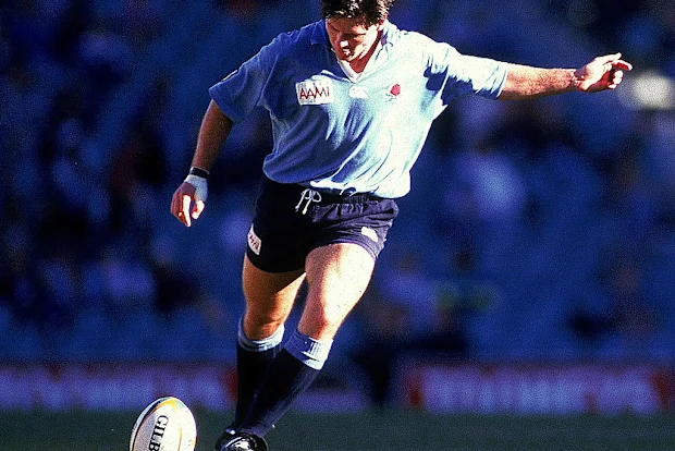 Matthew Burke, dos Waratahs, chuta para o gol no Sydney Football Stadium em 1996.