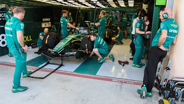 O chefe da Aston Martin, Adrian Newey, observa enquanto os mecânicos trabalham no AMR26 durante os testes de F1.
