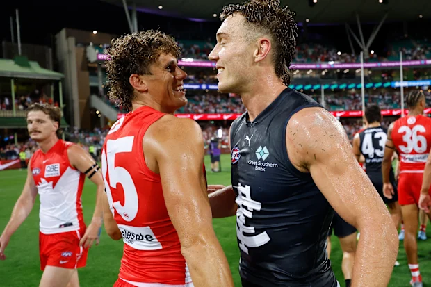 Charlie Curnow dos Swans e Patrick Cripps dos Blues se abraçam.
