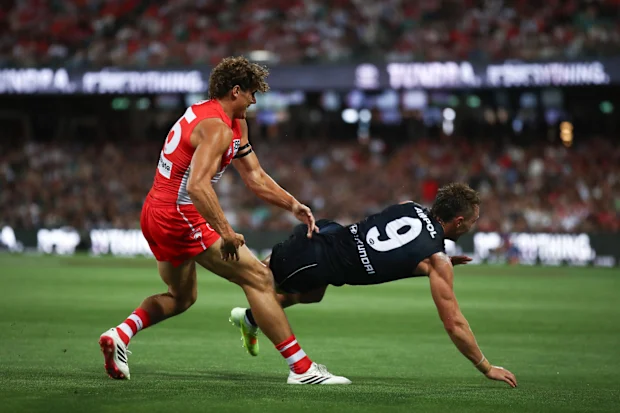 Charlie Curnow dos Swans entra em confronto com Patrick Cripps dos Blues.