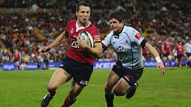 Clinton Schifcofske, dos Reds, é perseguido no gol por Tom Carter, dos Waratahs.