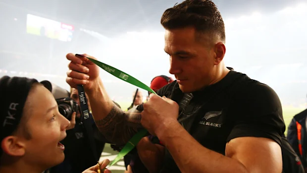 Sonny Bill Williams, da Nova Zelândia, entrega sua medalha ao jovem fã Charlie Lines.