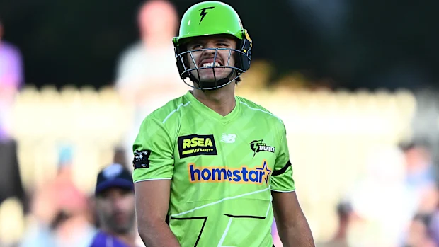 HOBART, AUSTRÁLIA - 16 DE DEZEMBRO: Sam Konstas do Thunder reage após ser atingido por uma entrega durante a partida BBL entre Hobart Hurricanes e Sydney Thunder no Ninja Stadium, em 16 de dezembro de 2025, em Hobart, Austrália (Foto de Steve Bell/Getty Images)