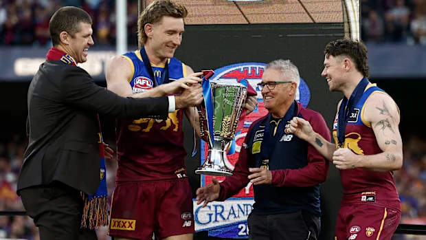 Jonathan Brown presenteia Harris Andrews dos Leões, Chris Fagan, treinador sênior dos Leões e Lachie Neale dos Leões com a Premiership Cup no palco durante a partida da Grande Final da AFL entre os Geelong Cats e os Brisbane Lions no Melbourne Cricket Ground em 27 de setembro de 2025 em Melbourne, Austrália. (Foto de Michael Willson/AFL Photos via Getty Images)