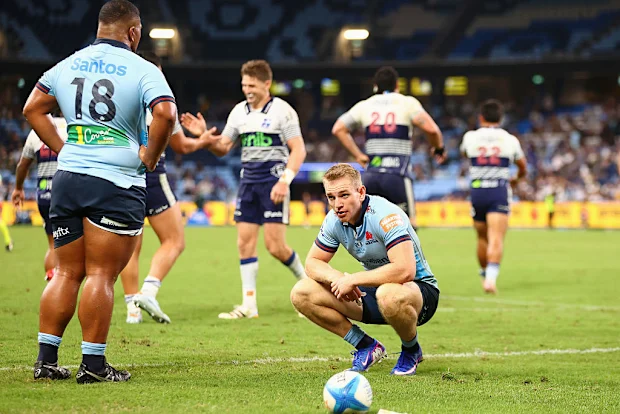 Joey Walton, dos Waratahs, parece abatido após uma tentativa do Blues.