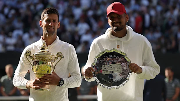 Novak Djokovic e Nick Kyrgios posam com seus troféus após a final de Wimbledon de 2022.