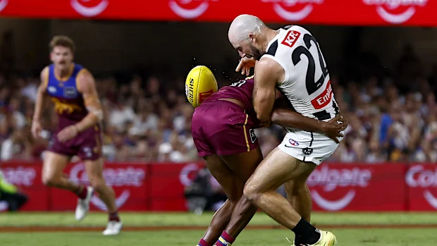 Steele Sidebottom dos Magpies é abordado por Keidean Coleman dos Leões.