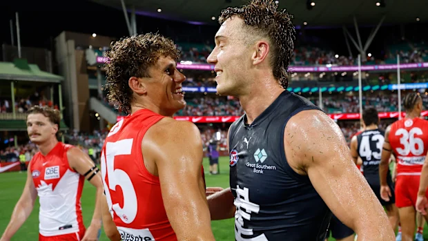 Charlie Curnow dos Swans e Patrick Cripps dos Blues se abraçam.