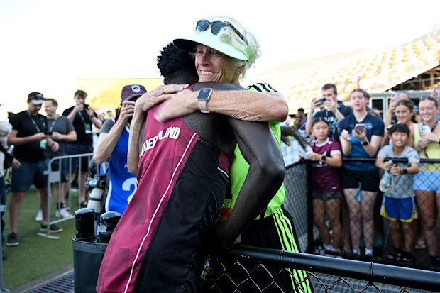 BRISBANE, AUSTRÁLIA - 18 DE ABRIL: Gout Gout abraça seu técnico Di Sheppard depois de vencer a final da prova masculina sub-20 dos 100m durante o Campeonato Australiano Júnior de Atletismo de 2026 no Queensland Sport and Athletics Centre em 18 de abril de 2026 em Brisbane, Austrália. (Foto de Bradley Kanaris/Getty Images)
