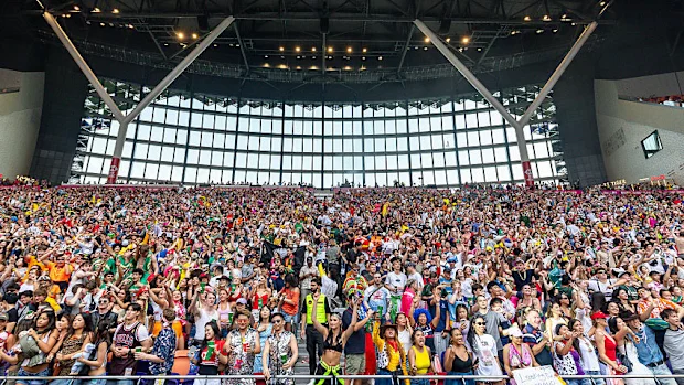 Os fãs torcem na arquibancada sul durante o terceiro dia do Hong Kong Sevens no Kai Tak Stadium.