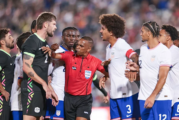 O árbitro Kwinsi Williams separa Cameron Burgess da Austrália e Chris Richards dos Estados Unidos.