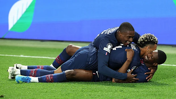 Khvicha Kvaratskhelia, do Paris Saint-Germain, comemora o quarto gol da sua equipe com Desire Doue e Nuno Mendes.