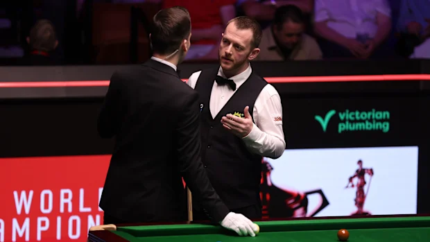 Mark Allen da Irlanda do Norte fala com o árbitro, Marcel Eckardt enquanto um re-rack é ameaçado devido às bolas vermelhas cobrindo o preto na caçapa do canto durante a partida semifinal entre Mark Allen da Irlanda do Norte e Wu Yize da China no décimo quarto dia do Halo World Snooker Championship no The Crucible Theatre em 01 de maio de 2026 em Sheffield, Inglaterra. (Foto de George Wood/Getty Images)