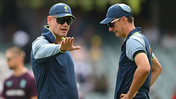 Andrew McDonald, técnico da Austrália, fala com Pat Cummins.