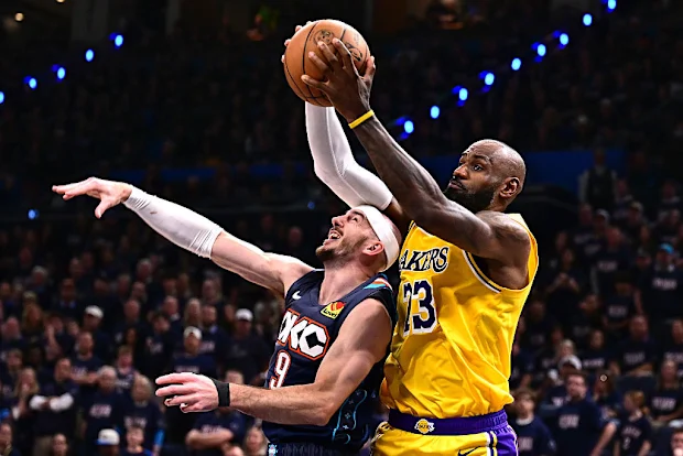 LeBron James atira em Alex Caruso, do Oklahoma City Thunder.