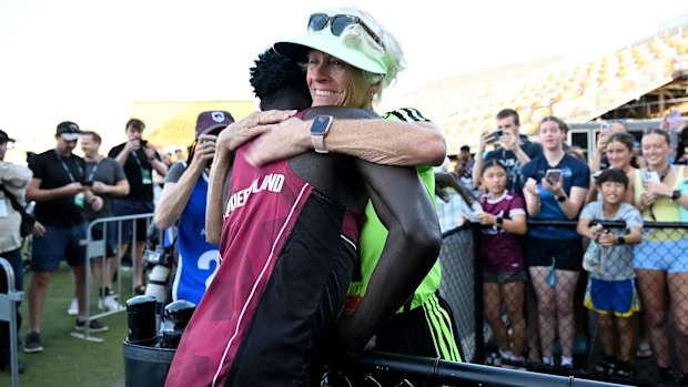 BRISBANE, AUSTRÁLIA - 18 DE ABRIL: Gout Gout abraça seu técnico Di Sheppard depois de vencer a final da prova masculina sub-20 dos 100m durante o Campeonato Australiano Júnior de Atletismo de 2026 no Queensland Sport and Athletics Centre em 18 de abril de 2026 em Brisbane, Austrália. (Foto de Bradley Kanaris/Getty Images)