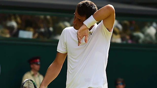 Bernard Tomic enxuga a testa na partida de 2015 contra Novak Djokovic.