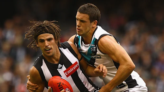 Scott Pendlebury, com dreadlocks, abordado por Travis Boak em 2011.