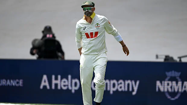 Nathan Lyon, da Austrália, se lesiona ao colocar a bola em campo.