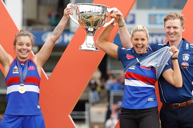Ellie Blackburn, Katie Brennan e Paul Groves erguem a copa da AFLW 2018.