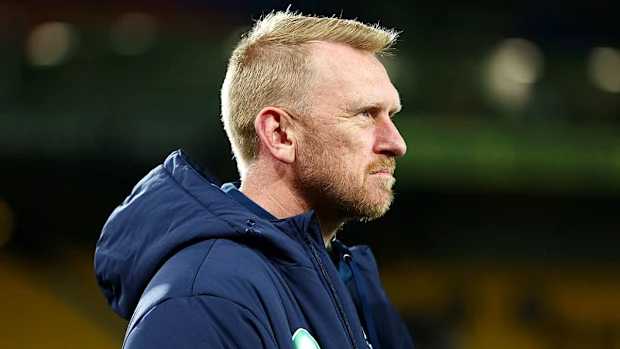 O técnico Andrew Webster, dos Warriors, observa.