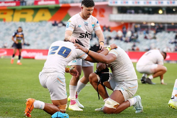 Os jogadores de Moana Pasifika rezam após vencer a partida da 16ª rodada do Super Rugby.
