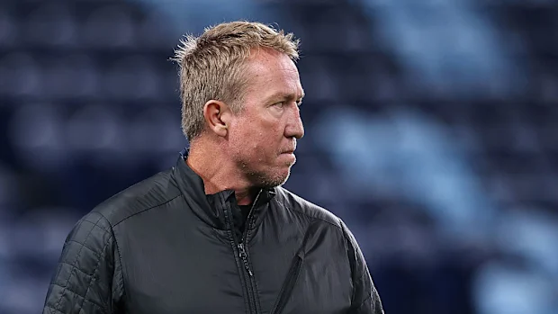O técnico do Roosters, Trent Robinson, observa o aquecimento dos jogadores do Brumbies.