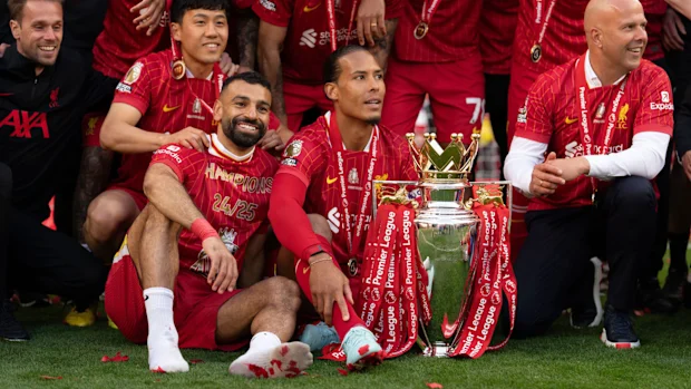 Wataru Endo, Mohamed Salah, Virgil van Dijk e Arne Slot do Liverpool seguram o Troféu da Premier League enquanto comemoram a coroação do Liverpool como campeão da Premier League na temporada 2024/25, após a partida da Premier League entre Liverpool FC e Crystal Palace FC em Anfield, em Liverpool, Inglaterra, em 25 de maio de 2025