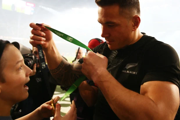Sonny Bill Williams entrega sua medalha a um jovem fã.